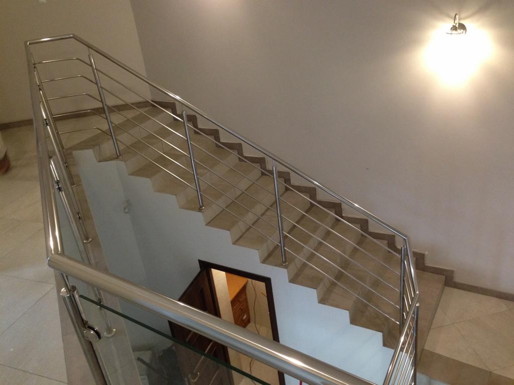 Nowoczesna balustrada nierdzewna ze szklanym wypełnieniem na schodach w Markowej. Minimalistyczny design, eleganckie wykończenie i subtelne oświetlenie.