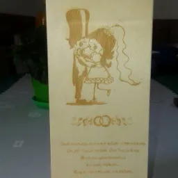 Drewniane pudełko z wygrawerowanym laserowo rysunkiem pary młodej, imionami Justyna i Piotr oraz datą 27.08.2016, prawdopodobnie jako pamiątka ślubna.