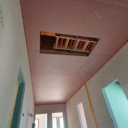 CENDRUS Michał Cendrowski - Sufit z płyt gipsowo-kartonowych, widoczne łączenia i otwór rewizyjny z elementami konstrukcyjnymi. Ściany przygotowane do dalszych prac wykończeniowych. Surowy stan wnętrza.