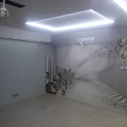 Pokój z nowocześnie wykończonymi ścianami i sufitem, z podświetleniem LED i fototapetą z motywem geometrycznym i kryształami, świeżo położona podłoga.