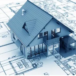 Model domu z dachem dwuspadowym, umieszczony na planie architektonicznym w odcieniach błękitu. Widoczny komin i balkon. Perspektywa z góry, oświetlenie równomierne.