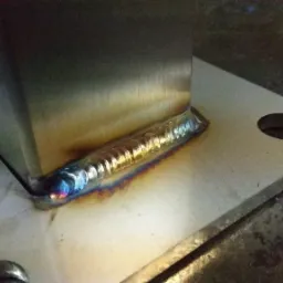 Precyzyjne spawanie metalowego profilu do płyty w Chorzenicach, widoczne tęczowe przebarwienia po spawaniu.