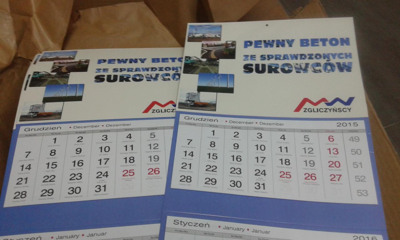 Dwa kalendarze firmowe z logo 'Zgliczyński' i hasłem 'Pewny Beton ze sprawdzonych surowców', z datami grudzień 2015 i styczeń 2016, na tle tekturowego pudełka.