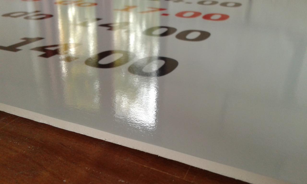 Błyszcząca tablica z nadrukowanymi godzinami w kolorze czarnym i czerwonym, ustawiona na drewnianej powierzchni.