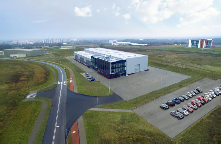 Nowoczesny budynek z przeszkloną fasadą, prawdopodobnie siedziba firmy z branży instalacyjnej, widok z lotu ptaka, parking pełen aut.