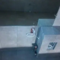 Ułożone szare płytki ścienne w łazience, widoczne przewody elektryczne i kratka wentylacyjna, ujęcie z góry.