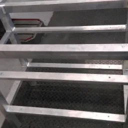 Konstrukcja z profili aluminiowych, spawana, tworząca szkielet mebla lub elementu architektonicznego, widoczne spawy i otwory montażowe.