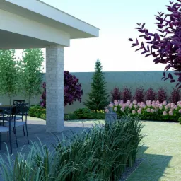 Zadaszony taras z kamienną kolumną, stołem i krzesłami, otoczony różnorodną roślinnością: trawy ozdobne, krzewy z fioletowymi liśćmi i kwitnące hortensje.
