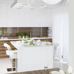 Nowoczesna kuchnia z wyspą, białe szafki górne i drewniane dolne, minimalistyczny design, oświetlenie sufitowe, obraz na ścianie.