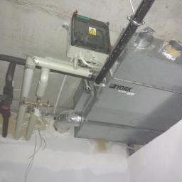 WNT Łukasz Wołowski - Widok instalacji rekuperacji w surowym stanie, widoczne rury, centrala rekuperacyjna marki York oraz przewody elektryczne.