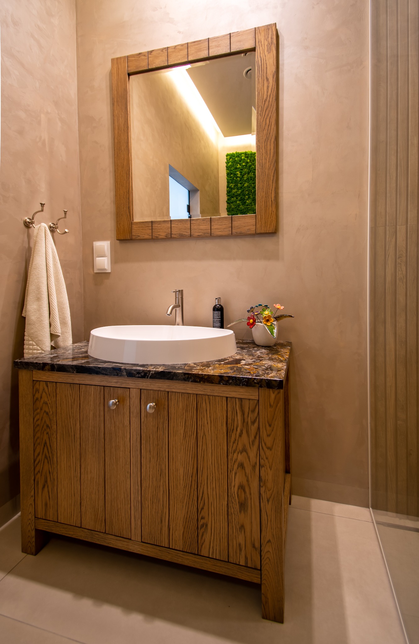 Nowoczesna łazienka w Albigowej: drewniana szafka z marmurowym blatem, okrągła umywalka, lustro w drewnianej ramie i dekoracje. Stylowe wykończenie.