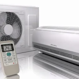 Biały klimatyzator dwuczęściowy z pilotem wskazującym temperaturę 24 stopnie Celsjusza, widoczny wentylator jednostki zewnętrznej i wyświetlacz jednostki wewnętrznej.