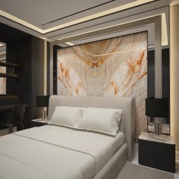 Ewelina Bulińska Architektura Wnętrz - Elegancka sypialnia z łóżkiem w odcieniach beżu, marmurową ścianą za wezgłowiem, biurkiem z krzesłem i lampkami nocnymi. Nowoczesny design wnętrza.
