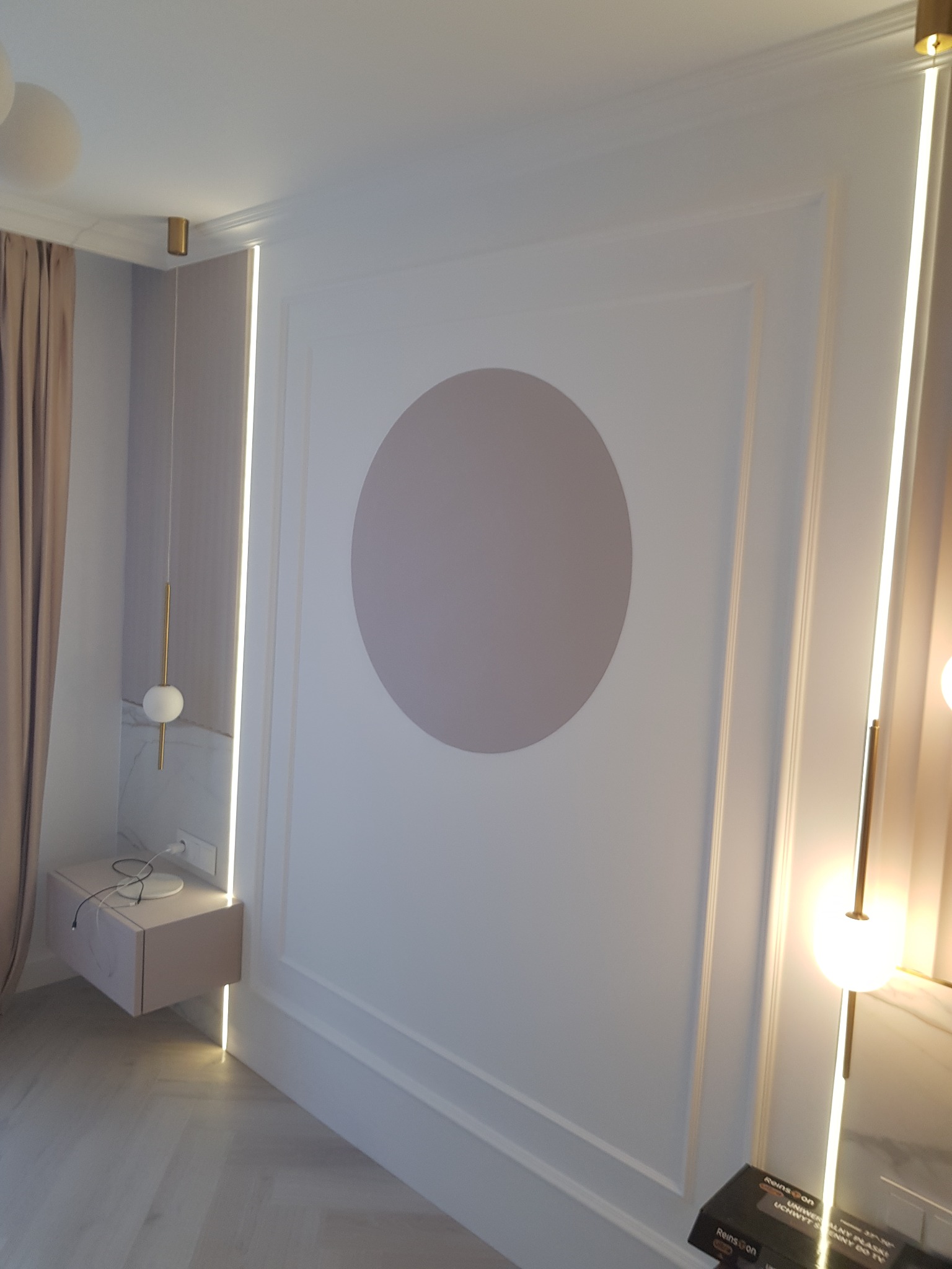 Eleganckie wnętrze pokoju z dekoracyjną ścianą w odcieniach bieli i szarości, ozdobioną dużym, szarym kołem; subtelne oświetlenie LED podkreśla architektoniczne detale i minimalistyczny styl...