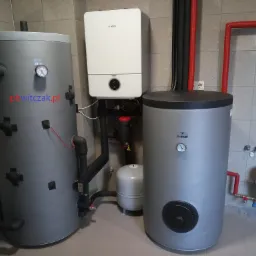 Nowoczesna kotłownia z kotłem gazowym Bosch, dwoma szarymi zbiornikami Galmet i instalacją hydrauliczną w pomieszczeniu z szarymi płytkami.