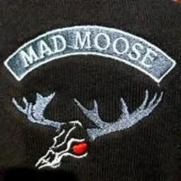 Czarne ubranie z wyhaftowanym logo 'MAD MOOSE' przedstawiającym głowę łosia z czerwonym nosem i srebrnymi porożami.
