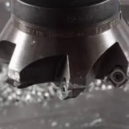 Frez trzpieniowy z widocznymi ostrzami i wiórami metalu, po obróbce skrawaniem. Detal narzędzia w zbliżeniu, ukazujący precyzję wykonania.