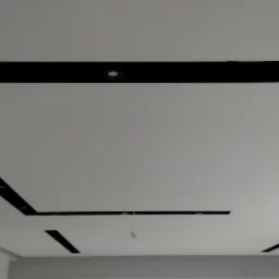 Nowoczesny sufit podwieszany z czarnymi wnękami i oświetleniem punktowym. Minimalistyczny design, biała powierzchnia sufitu. Widok z dołu, podkreślający geometrię.