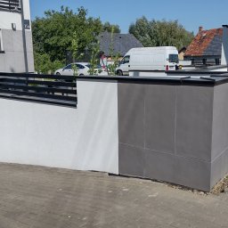 IZO-PLUS PAWEŁ WALSKI - Nowoczesne ogrodzenie posesji w Kruszynie: biały tynk strukturalny kontrastuje z szarymi panelami. Metalowe, poziome przęsła. Widoczne pojemniki na odpady.