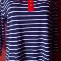 Granatowo-biała bluzka w paski z czerwonymi akcentami na manekinie. Widoczna metka. Casualowy styl, długi rękaw.