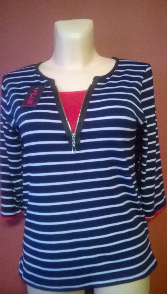 Granatowo-biała bluzka w paski z zamkiem błyskawicznym na manekinie, z czerwoną wstawką pod spodem i metką z nazwą marki.
