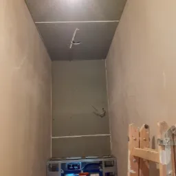 Montaż stelaża podtynkowego WC z płytą karton gips na ścianie w trakcie remontu łazienki, widoczna drabina malarska.