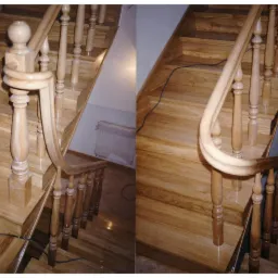 Dwu-częściowe ujęcie jasnych, drewnianych schodów z toczonymi balustradami, widok z góry, widoczny kabel elektryczny i grzejnik w tle.