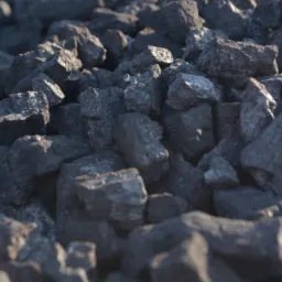 Kupa antracytu o nieregularnych kształtach, niektóre bryły lekko połyskują w padającym świetle.