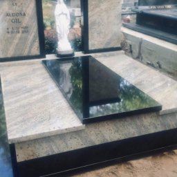 Kamieniarstwo Dziobak Radosław - Nowoczesny nagrobek z jasnego granitu i czarnego kamienia, z rzeźbą Matki Boskiej w tle, na cmentarzu.