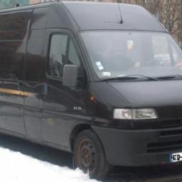 Ed-Mar Monika Kuraś - Czarny bus Citroen Jumper z żółtym pasem na boku, zaparkowany na śniegu. Widoczne tablice rejestracyjne i sylwetka kierowcy w kabinie.