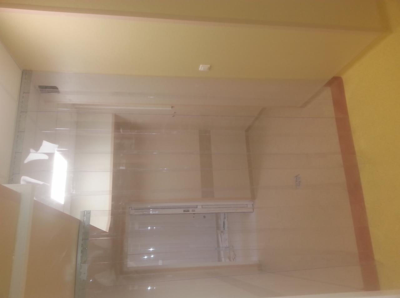 Wnętrze pomieszczenia z zamontowanymi panelami z tworzywa sztucznego, tworzącymi rodzaj kurtyny. Widoczne oświetlenie i elementy wyposażenia wnętrza.