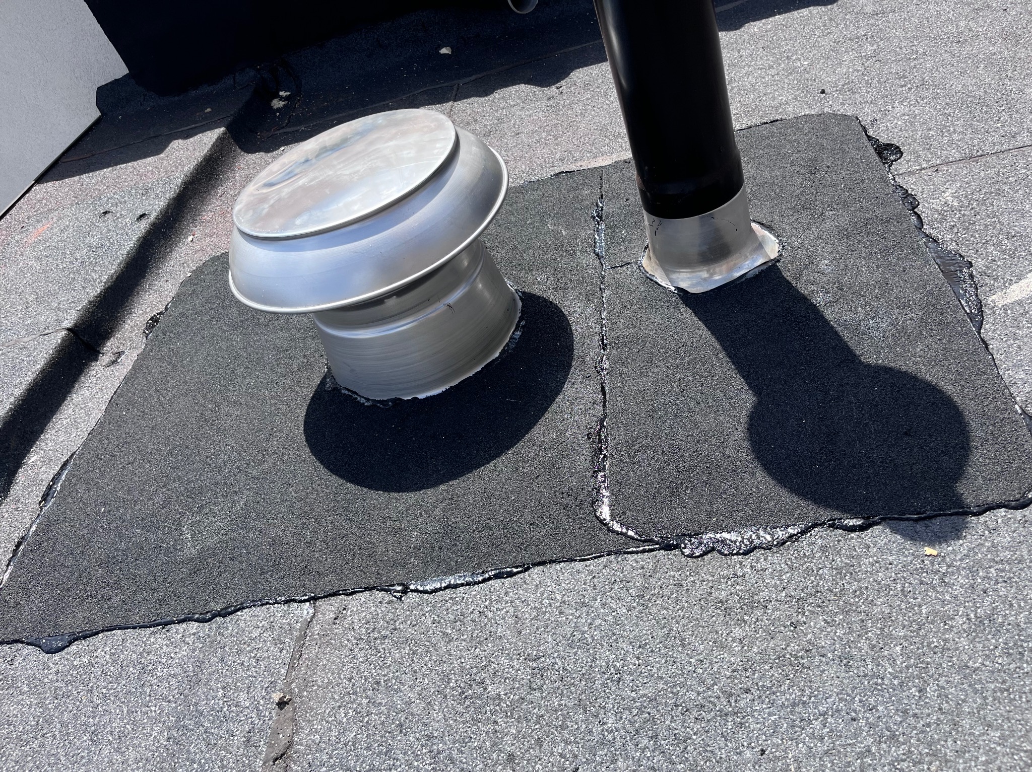 Szczelne przejście kominowe i wentylacyjne na dachu pokrytym papą. Obróbka blacharska z uszczelnieniem dekarskim. Detal wykonania.