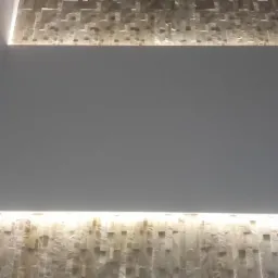 Ściana z dekoracyjną płytką imitującą kamień, podświetlona listwami LED, z widocznymi punktowymi lampami na bocznej ścianie.