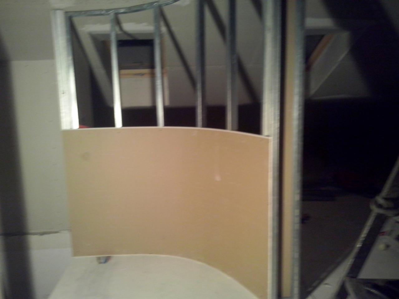 Nietypowa konstrukcja z płyt karton-gips, metalowy stelaż, sufit pod skosem. Wnętrze w trakcie prac wykończeniowych, widoczne elementy konstrukcyjne.