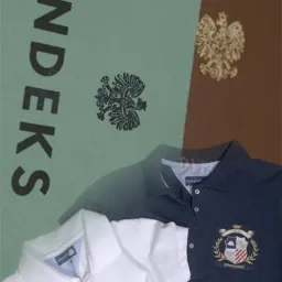 Dwa polo z haftowanymi herbami na tle okładki książki z orłem i napisem INDEKS, w kolorach zieleni i brązu. Widoczne detale haftu i faktura materiałów.