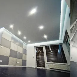 Nowoczesne wnętrze: szare ściany, sufit z oświetleniem punktowym, dekoracyjna ściana z kwadratowych paneli w odcieniach szarości i beżu, ciemna podłoga, białe drzwi i okno z żaluzjami.