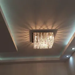 Kryształowy żyrandol kwadratowy w podwieszanym suficie z oświetleniem LED punktowym i dekoracyjnym podświetleniem obniżonej części sufitu.