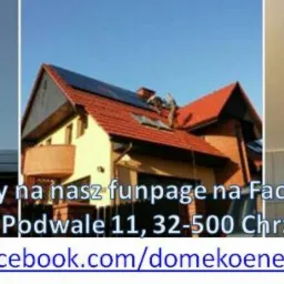 Instalacja fotowoltaiczna na dachu domu jednorodzinnego, widoczny inwerter na ścianie.  Ujęcie z dołu, błękitne niebo w tle. Na dole tekst reklamowy.