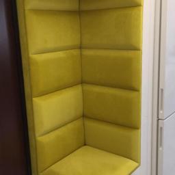 Usługi remontowo-budowlane Łukasz Cywiński - Żółty, tapicerowany narożnik wnękowy z siedziskiem i oparciem podzielonym na kwadratowe panele, umieszczony w rogu pomieszczenia z widocznymi drzwiami i białą lodówką.