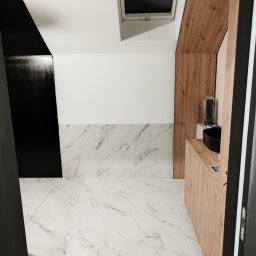 Gładko.pl - Nowoczesna łazienka z białymi marmurowymi płytkami podłogowymi i ściennymi, czarnymi akcentami na ścianach i drewnianą zabudową umywalki, doświetlona oknem dachowym.