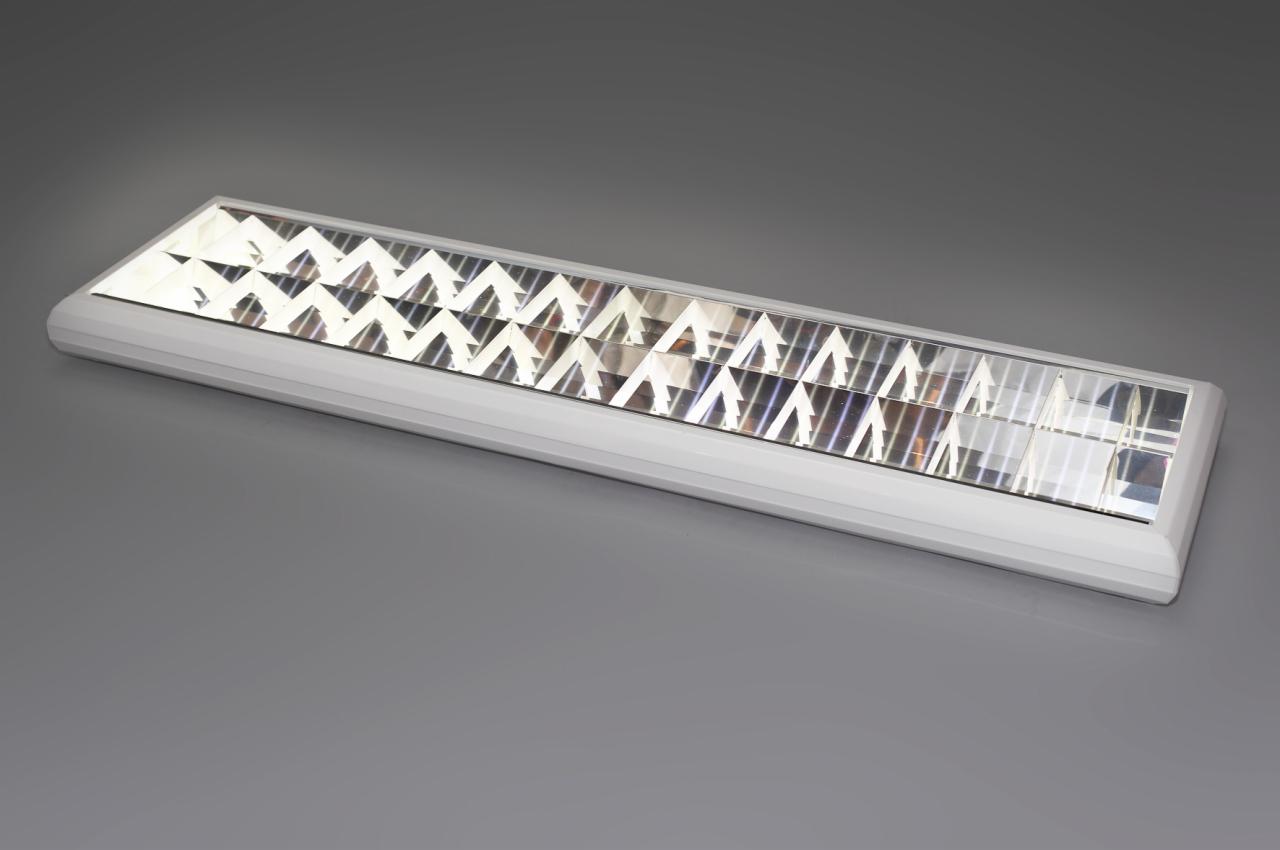 Podłużna, biała lampa sufitowa z geometrycznym wzorem odbijającym światło, prezentowana na szarym tle. Lampa w stylu nowoczesnym, gotowa do montażu.