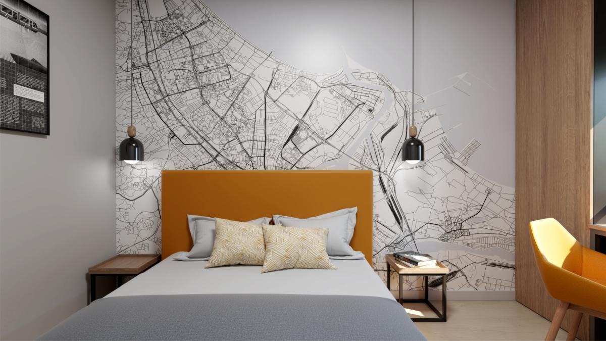 Nowoczesna sypialnia z żółtym zagłówkiem i tapetą w formie mapy miasta, minimalistyczne lampy wiszące, drewniane szafki nocne.