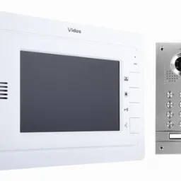 Zestaw wideodomofonowy Vidos: biały panel wewnętrzny z ekranem i srebrny panel zewnętrzny z kamerą i przyciskami. Widoczne logo Vidos na obu elementach.