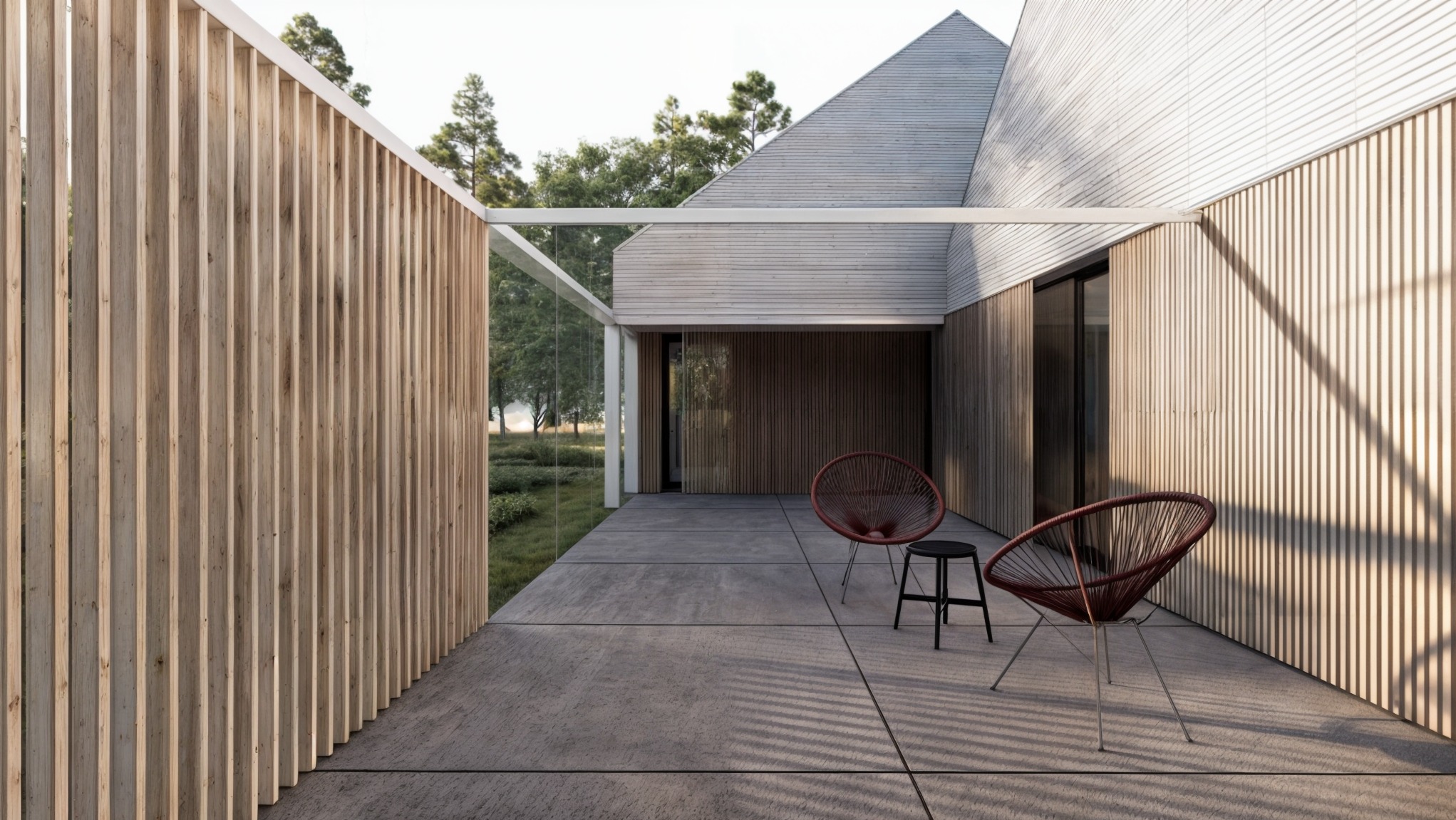 Nowoczesny taras z drewnianą elewacją, ażurową ścianą z pionowych desek i minimalistycznymi krzesłami z cienkich linek w kolorze bordo, oświetlony popołudniowym słońcem rzucającym cienie.