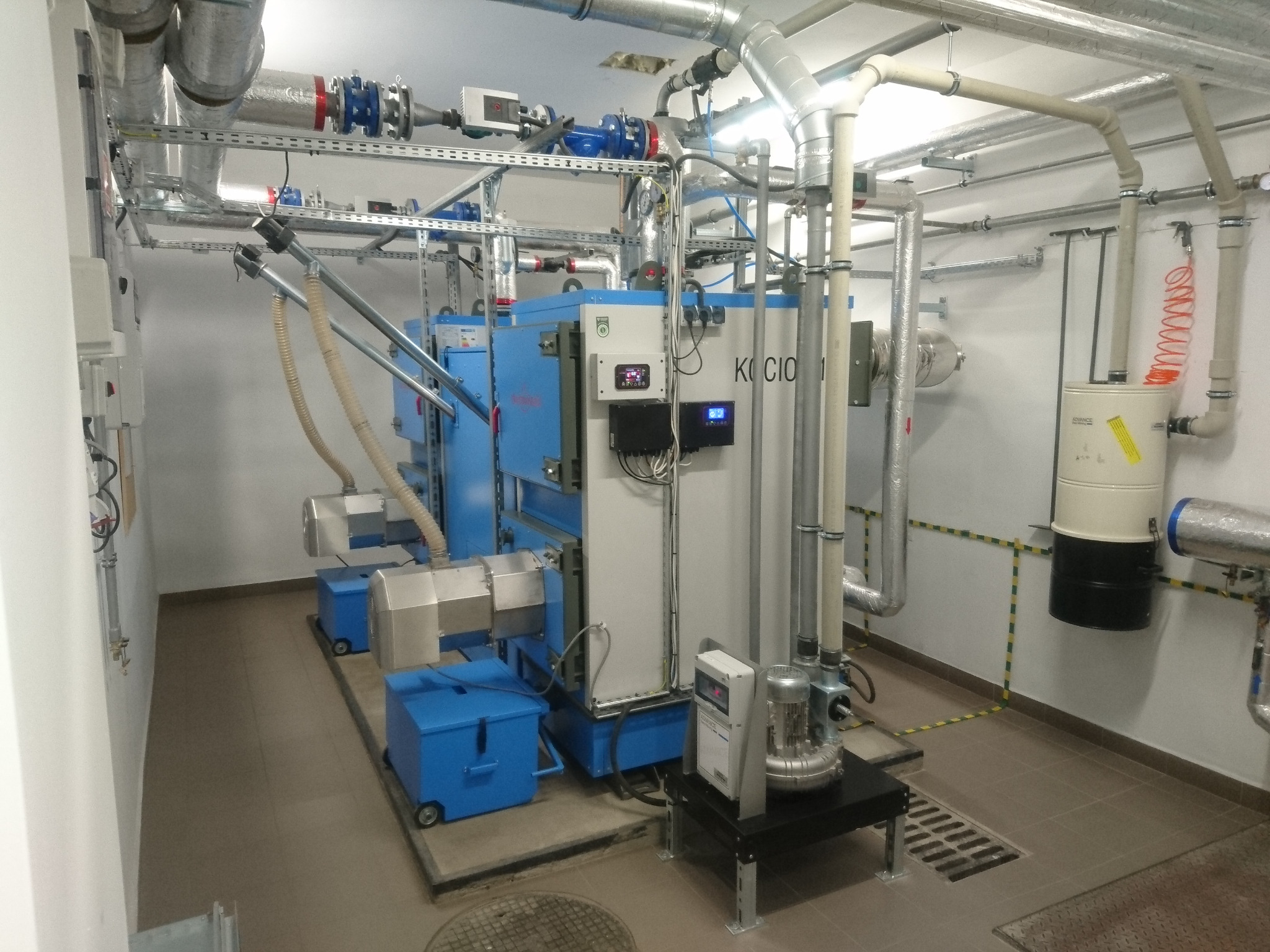 Kompleksowa kotłownia pelletowa z automatycznym odpopielaniem, pneumatycznym podawaniem pelletu i rozbudowaną instalacją rur.