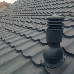 Szary dach z blachodach&oacute;wki z kominkiem wentylacyjnym, widok z g&oacute;ry.