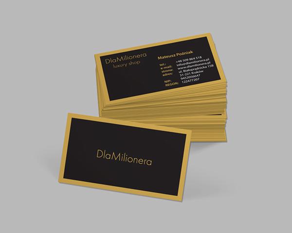 Stos czarno-złotych wizytówek z danymi firmy 'DlaMilionera luxury shop', jedna wizytówka leży obok stosu, prezentując nazwę firmy.