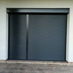 Deco-Light - Zamknięta, grafitowa osłona okienna z widoczną poziomą strukturą lamel, zamontowana na jasnej elewacji budynku z ozdobnym cokołem.