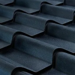 Ciemna, matowa blacha trapezowa w zbliżeniu, ułożona warstwami. Widoczna tekstura i regularny wzór fal. Precyzyjne wykonanie, nowoczesny design.