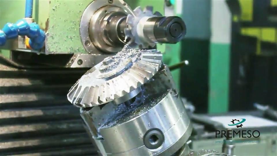 Precyzyjna obróbka metalu: frezowanie skośnego koła zębatego na obrabiarce CNC z chłodziwem, widoczne wióry i logo firmy Premeso.